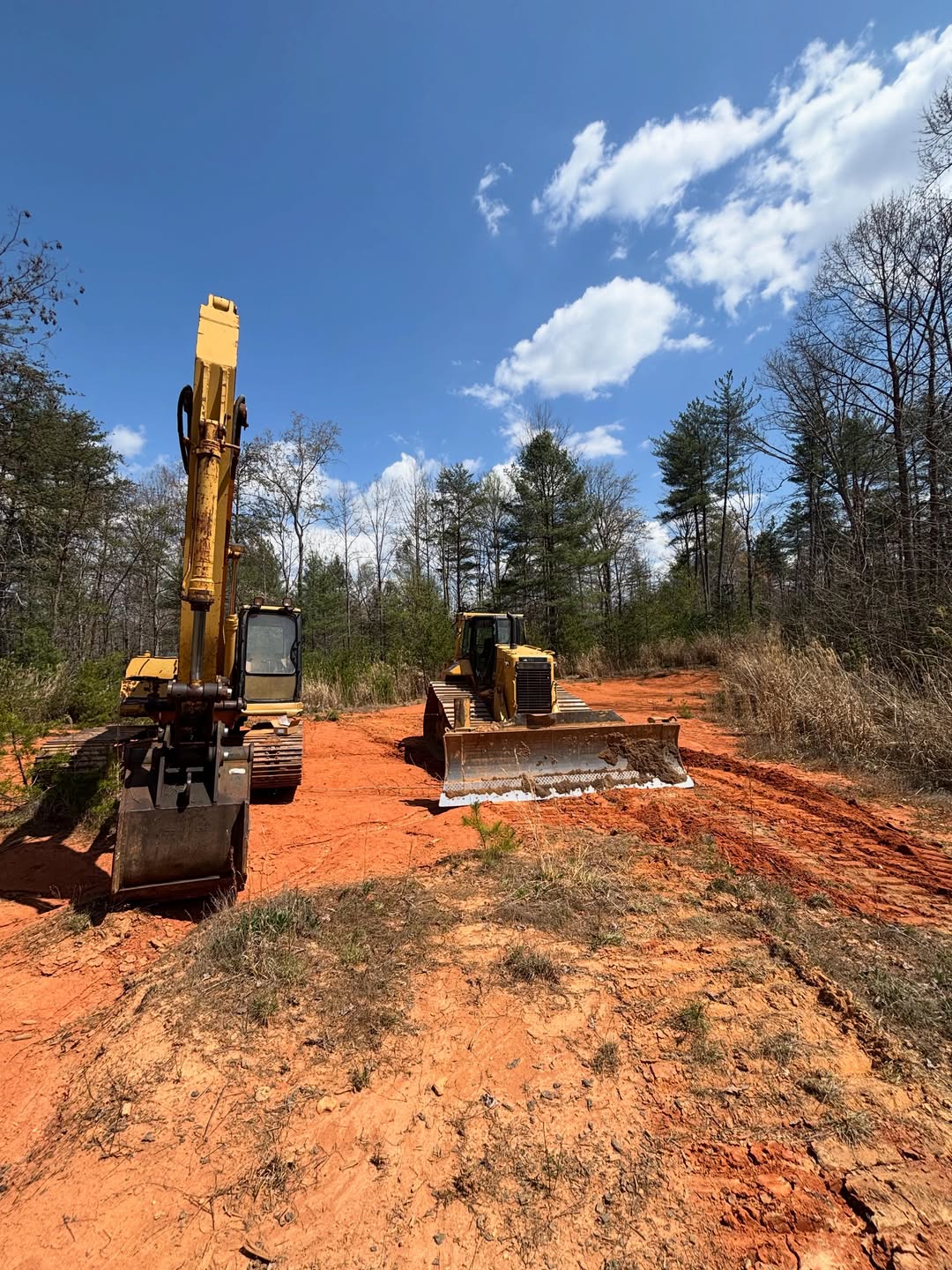 Excavator and dozer staged on a clearing job site